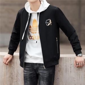Men's black stand-collar jacket with embroidery over white hoodie and grey jeans