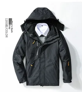Detail view of dark grey 3-in-1 outdoor hooded jacket with yellow zipper pulls and pockets