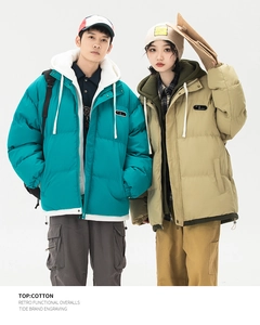 Detail of peacock blue and khaki winter hooded puffer jackets with drawstring and logo