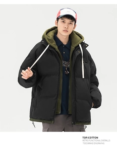 Detail of men's layered techwear jacket with black windproof fabric and green hood