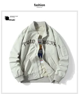 Detail of khaki bomber jacket featuring utility sleeve pocket and 3D chest embroidery