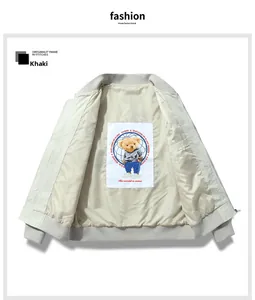 Detail of khakhi bomber jacket interior featuring a teddy bear patch and ribbed cuffs