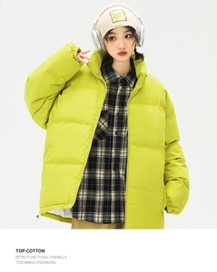 Dettaglio del piumino verde brillante con zip a collo alto e trama trapuntata elegante