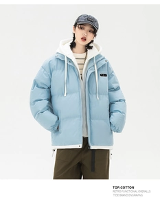 Detail of light blue hooded puffer jacket with circular chest badge and white drawstring