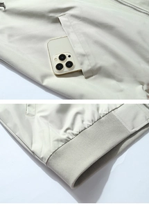 Detail view of the embroidered baseball jacket showing functional side pockets and ribbed hem
