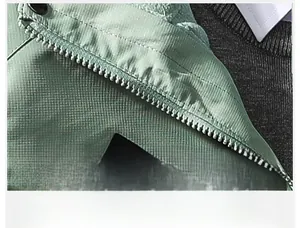 Detailed close-up of high-quality smooth metal zipper on mint green outdoor jacket