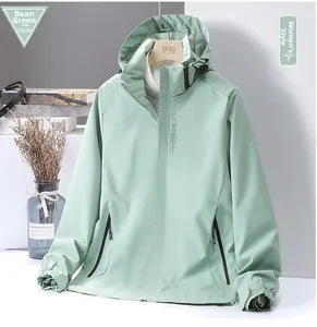 Detail view of water-resistant light green jacket featuring Explore chest logo print