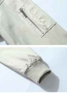 Detail view of American bomber jacket sleeve with zip pocket and ribbed knitted cuff