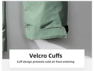 Detail view of adjustable velcro cuff on a green windproof ripstop outdoor jacket