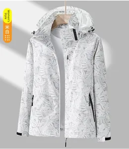 Détail d'une veste à capuche coupe-vent blanc crème avec motif de feuilles de palmier gris