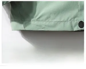 Detail view of ripstop fabric texture and precise stitching on outdoor jacket hem