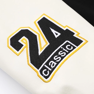 Detailed close-up of embroidered number 24 patch on textured white baseball jacket