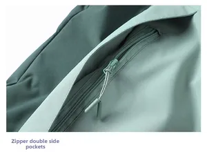 Macro detail of waterproof zippered side pockets on two-tone green outdoor jacket