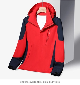 Detail view of red and navy blue outdoor hooded jacket with waterproof zipper pockets