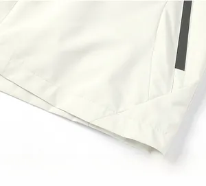 Detail of white outdoor jacket showing hem stitching, grid fabric and waterproof zipper