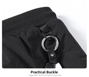 Détail du tissu noir durable avec une boucle en métal argenté et le logo sur le pantalon