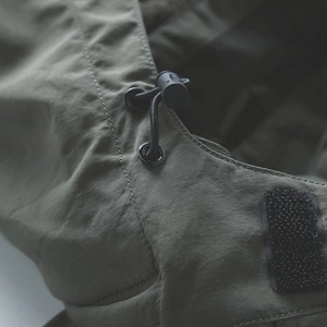 Veste de randonnée pour homme vert armée avec cordon de serrage et détails techniques