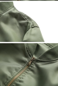Detail view of military green bomber jacket with metal zipper and ribbed collar texture