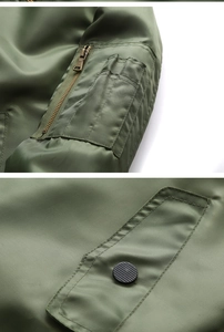 Detail of army green bomber jacket sleeve zip pocket and snap button flap pocket