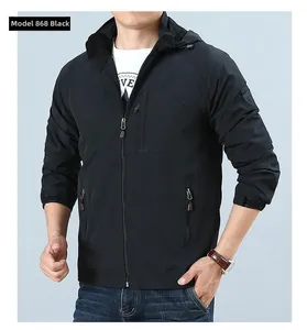 Detail of men's black hooded outdoor jacket featuring functional zipper pockets and badge
