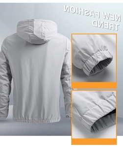 Detail view of a men's light grey hooded windbreaker showing elastic cuffs and hem design