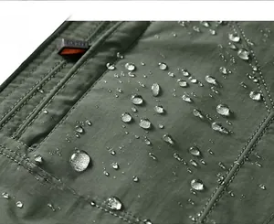 Close-up of olive waterproof jacket fabric with water droplets and double stitching