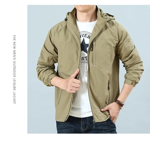 Detail of khaki men's lightweight outdoor jacket featuring hood and zipper pockets