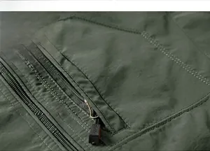 Macro shot of zippered pocket and stitching on a military green outdoor jacket