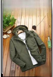 Detail of army green military jacket featuring an embroidered sleeve shield patch