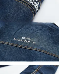 Detailed close-up of dark blue denim jacket embroidery and yellow contrast stitching