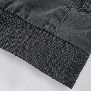 Detail of grey washed cotton jacket showing elastic ribbed hem and double-stitched seams