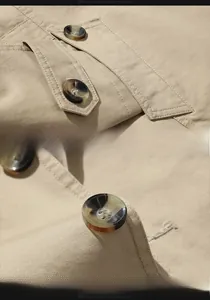 Detailed close-up of khaki cotton jacket showing tortoise buttons and double stitching