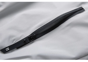 Detail of light grey functional fabric with black waterproof zipper and decorative 11 puller
