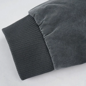 Detailed macro view of the elastic ribbed cuffs on a charcoal gray washed cotton jacket