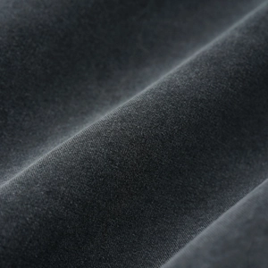 Macro shot of dark charcoal pure cotton fabric showing fine weave texture and soft drape