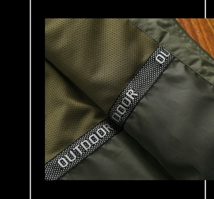 Detailed macro view of army green outdoor jacket featuring breathable mesh lining and strap