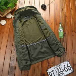 Army green waterproof outdoor hooded jacket with a dual-color lining on wood background