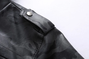 Détail de l'épaule d'une veste en cuir camouflage noir avec patte et bouton en métal