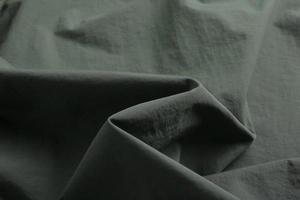 Close-up of olive green cargo jacket showing high-density woven texture and fabric detail