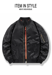 Detail of MA-1 flight jacket showing black outer fabric, orange lining, and arm pocket