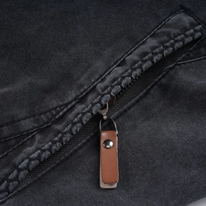 Close-up of vintage cotton jacket pocket with metal zipper and brown leather pull tab
