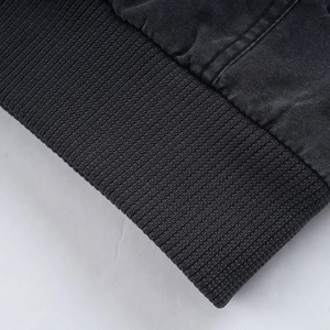 Detail of washed black canvas jacket featuring ribbed cuffs and reinforced stitching