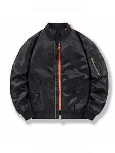 Close-up of black bomber jacket with bright orange lining and utility sleeve pocket