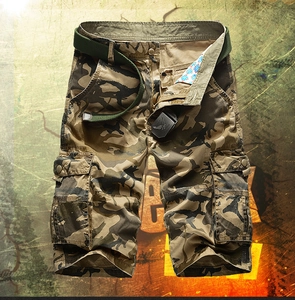 Detail of tactical camo cargo shorts showing metal eagle buckle belt and flap pocket