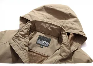 Detail of khaki outdoor jacket showing the detachable hood and brown mesh lining