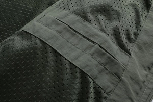 Close-up of olive green tactical jacket featuring breathable mesh fabric and durable stitching