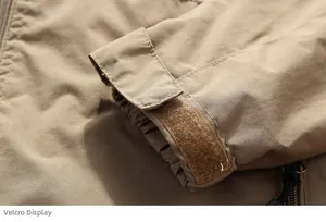 Detail of khaki tactical jacket cuff featuring adjustable velcro strap and elastic windproof hem