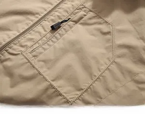 Detail of khaki tactical jacket showing zip pocket with SPORTS logo puller and ripstop fabric