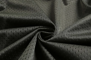 Detailed macro view of black breathable mesh fabric texture on men's outdoor jacket