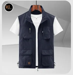Détail du gilet utilitaire bleu marine avec plusieurs poches et broderie de montagne